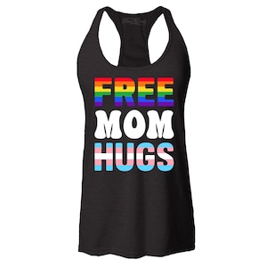 May include: Black racerback tank top with the text "FREE MOM HUGS" in rainbow, white, and transgender pride flag colors. The top is a sleeveless design, perfect for warm weather or layering.