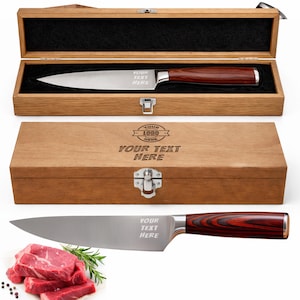 May include: A stainless steel chef's knife with a dark wood handle, presented in a wooden box. The box and knife blade feature the text "YOUR TEXT HERE". The knife is displayed with raw meat and rosemary.