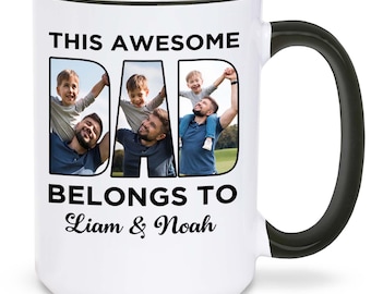 Puede incluir: Taza de cerámica blanca con asa y borde negros, con el texto "THIS AWESOME DAD BELONGS TO Liam & Noah". La palabra "DAD" está llena de fotos de un padre y sus hijos. La taza está llena de una bebida similar al café.