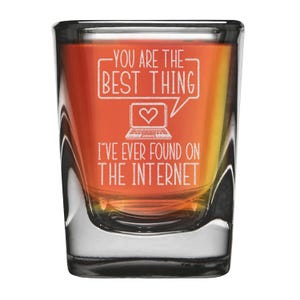 Op de afbeelding: Een helder glazen shotglas met een lichtbruine vloeistof erin. Het glas is gegraveerd met de tekst "You are the best thing I've ever found on the internet." en een klein beeld van een laptop met een hart op het scherm.