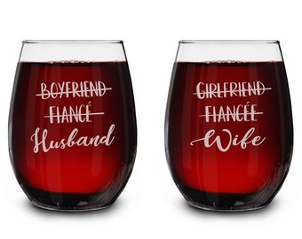Könnte beinhalten: Zwei stiellose Weingläser, gefüllt mit roter Flüssigkeit. Auf einem Glas stehen die Worte "BOYFRIEND", "FIANCÉ" und "Husband". Auf dem anderen Glas stehen "GIRLFRIEND", "FIANCÉE" und "Wife".
