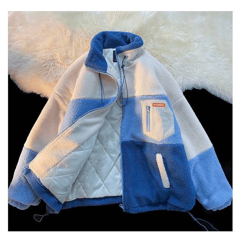May include: A blue and white fleece jacket with a zipper closure and a small pocket on the left side. The jacket is lined with a white quilted fabric.