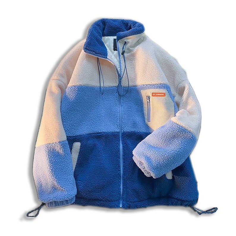 May include: A blue and white fleece jacket with a zipper closure and a small pocket on the right side. The pocket has a zipper and a small orange label with the text "DC Mountaineer".