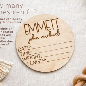 K&ouml;nnte beinhalten: Ein rundes Schild aus Holz mit dem Text "EMMETT john michael" und Platz f&uuml;r Datum, Uhrzeit, Gewicht und L&auml;nge. Das Schild ist hellbraun und hat eine nat&uuml;rliche Holzmaserung.