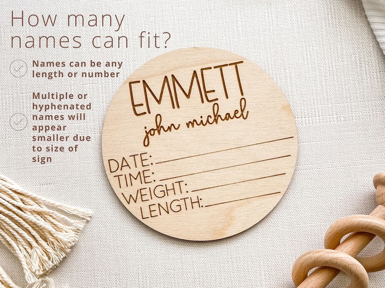 K&ouml;nnte beinhalten: Ein rundes Schild aus Holz mit dem Text "EMMETT john michael" und Platz f&uuml;r Datum, Uhrzeit, Gewicht und L&auml;nge. Das Schild ist hellbraun und hat eine nat&uuml;rliche Holzmaserung.