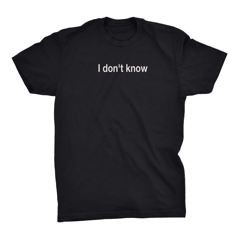 May include: A black short-sleeved t-shirt featuring the text "I don't know" printed in white across the center of the chest. The garment has a crew neckline and a standard fit, showcasing a simple design with clear, legible white lettering.