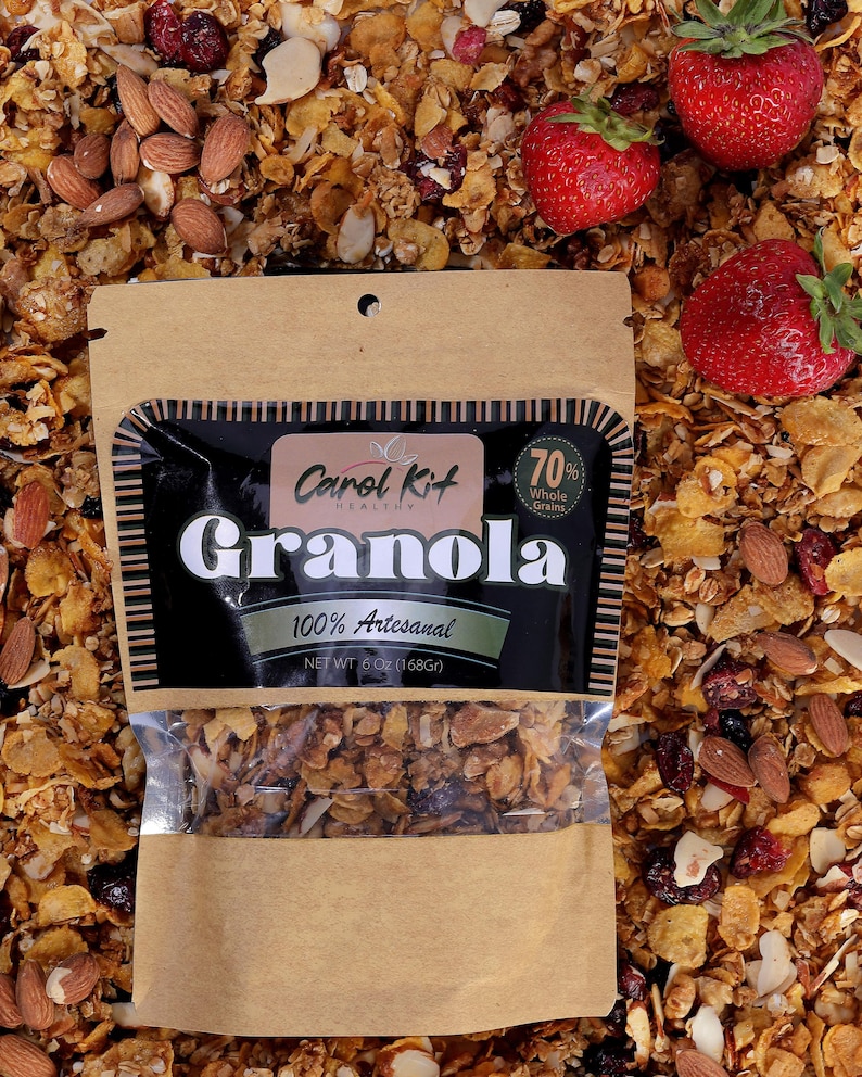 Puede incluir: Una bolsa de papel marr&oacute;n con una ventana de pl&aacute;stico transparente que muestra granola en su interior. La bolsa tiene una etiqueta negra con el texto "Carol Kit HEALTHY Granola 70% Whole Grains 100% Artesanal NET WT 6 OZ (168Gr)".