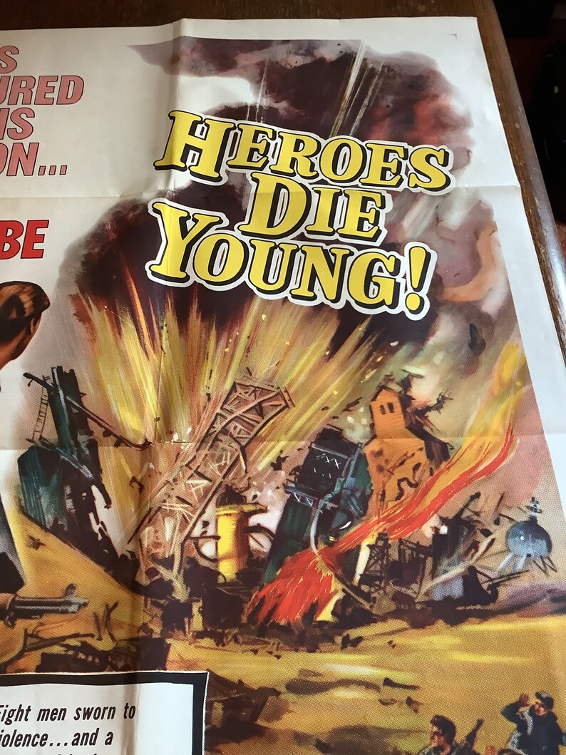 Op de afbeelding: Een vintage filmposter voor de film "Heroes Die Young". De poster toont een dramatische afbeelding van een grote explosie met een vurige rode en oranje rookpluim. De titel van de film is in grote gele letters op een witte achtergrond geschreven.