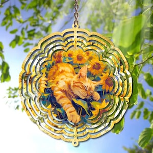 May include: A gold metal wind spinner with a sleeping orange tabby cat surrounded by sunflowers. The wind spinner has multiple layers of metal circles.