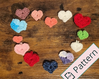 May include: A collection of crocheted hearts in various colors, including red, blue, green, pink, and white, arranged in a heart shape on a wooden surface. The text "Pattern" is written in pink on a white rectangle with a smaller white rectangle containing the word "PDF" below it.