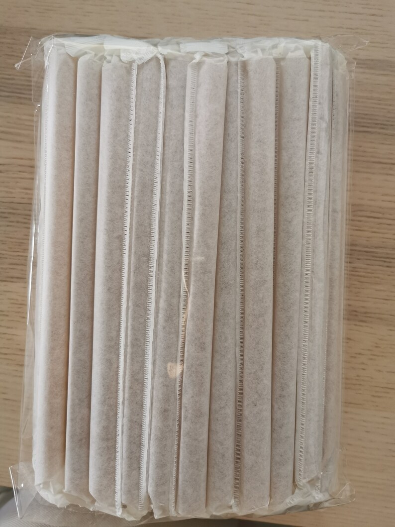 May include: A package of white paper straws, wrapped in clear plastic. The straws are bundled together and are ready to be used.