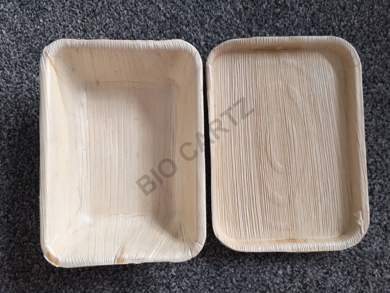 May include: Two rectangular, light brown, disposable plates made from palm leaves. The plates are made by Bio Cartz.