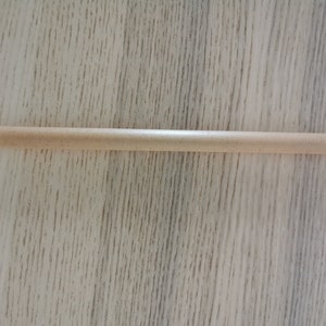 May include: A light brown, wooden drinking straw.