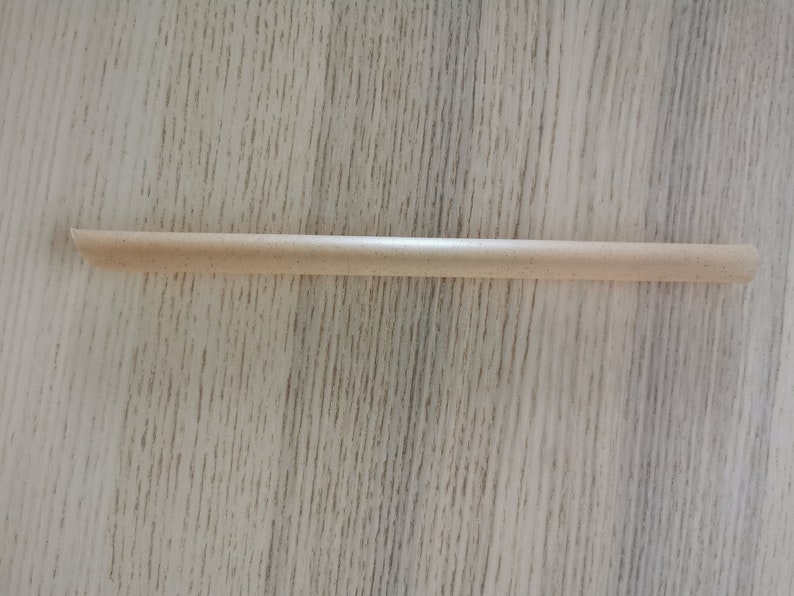 May include: A light brown, wooden drinking straw.