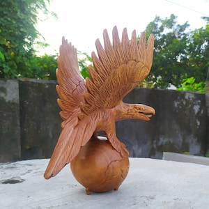 Wooden eagle carving with globe