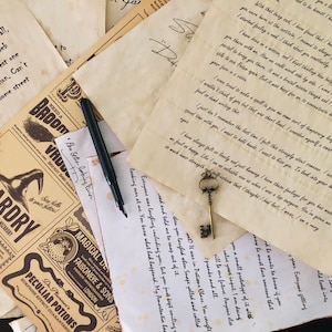 May include: A collection of aged, parchment-style papers featuring printed text and handwritten letters, a black fountain pen, and a small, ornate metal skeleton key. The papers include a Wizardry guide, potion labels, and personal correspondence.