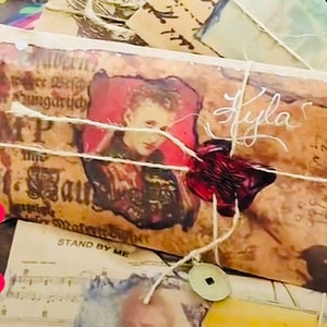 May include: A collection of vintage-style envelopes and papers tied with twine, featuring printed portraits, musical notation, and text including "Hogwarts Scotland" and "Stand By Me." The envelopes are sealed with red and blue wax seals and a metal coin.