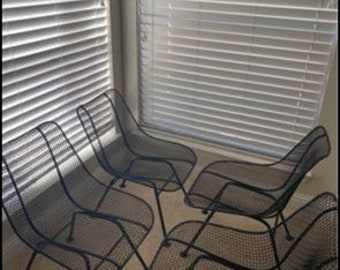 May include: Five black metal mesh chairs with a simple design. The chairs are arranged in a row, facing the same direction.