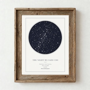 Puede incluir: Un mapa estelar impreso y enmarcado que muestra un cielo nocturno circular azul oscuro con constelaciones blancas. El texto dice: THE NIGHT WE SAID I DO, Charleston, South Carolina, 15th June 2024, 8:30 PM, Olivia & Benjamin. El marco es de madera marrón rústica.