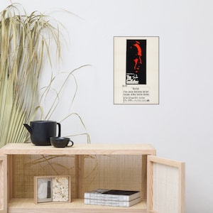 May include: A vintage movie poster for the film "The Godfather" featuring a red silhouette of Marlon Brando's face. The poster has a black border and white background.