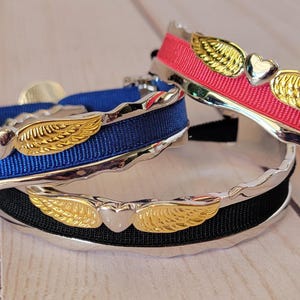 May include: Three silver bracelets with gold wings and heart charms. The bracelets are decorated with blue, black, and red ribbon.