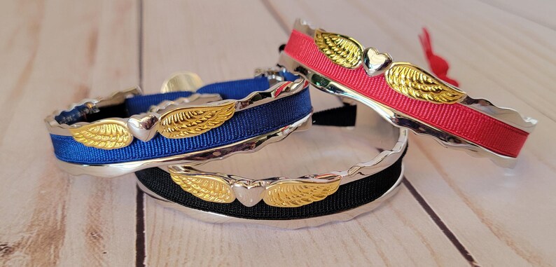 May include: Three silver bracelets with gold wings and heart charms. The bracelets are decorated with blue, black, and red ribbon.