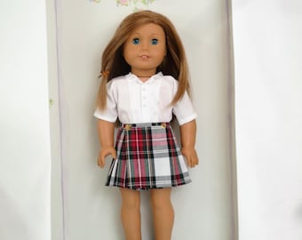 May include: A doll wearing a white button-up shirt and a red, black, and white plaid skirt. The doll has long brown hair and blue eyes.