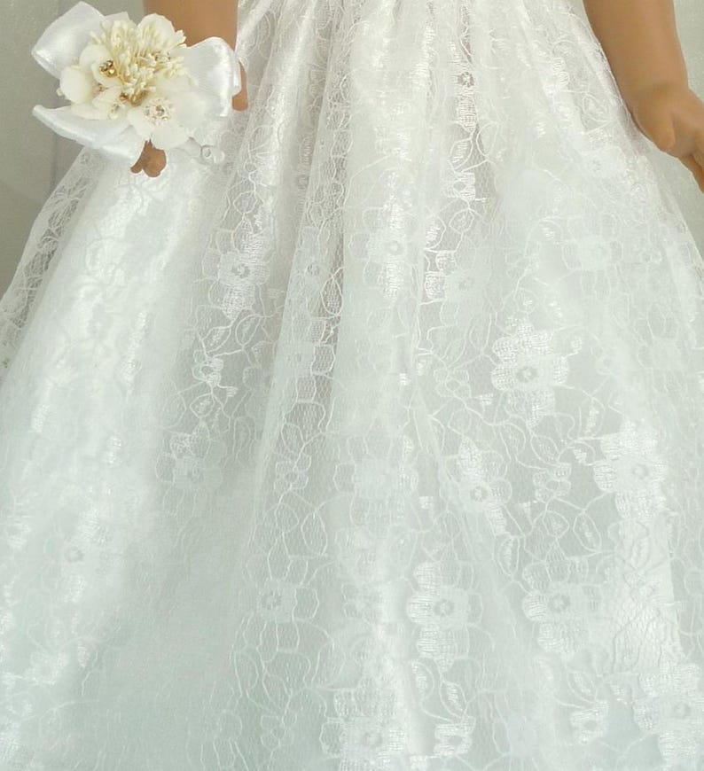 May include: White lace dress with a floral pattern. The dress has a full skirt and is made of a soft, delicate fabric.