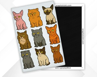 May include: A rectangular magnet featuring cartoon cats in various colors and breeds. The cats have grumpy expressions and are arranged in a grid pattern. The website address snapitstickit.com is printed on the magnet.