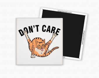 May include: A square magnet with a white background featuring a cartoon orange tabby cat with its legs in the air and the text "DON'T CARE" in bold black letters. A second black magnet is visible.