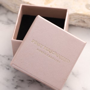 May include: A light pink gift box with a gold embossed logo that reads "Pink Personalized North Carolina".