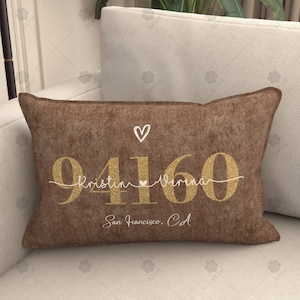 Könnte beinhalten: Braunes Kissen mit goldener Glitzerbeschriftung "94160 Kristin Verena San Francisco, CA".