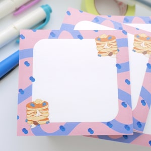 Könnte beinhalten: Rosa und blaue Notizkarten mit einem Stapel Pfannkuchen, die mit Blaubeeren belegt sind. Die Karten haben einen weißen Bereich zum Schreiben.