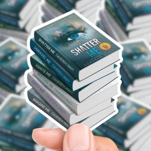 May include: A stack of stickers featuring the book covers from the "Shatter Me" series by Tahereh Mafi. The top sticker shows a blue eye and the title "Shatter Me." Other titles include "Unravel Me," "Ignite Me," "Restore Me," "Defy Me," and "Imagine Me."