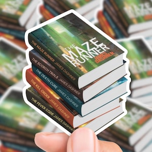 Puede incluir: Una pila de cinco libros de la serie "The Maze Runner" de James Dashner. Los títulos incluyen "The Maze Runner", "The Scorch Trials", "The Death Cure", "The Kill Order" y "The Fever Code". Las portadas de los libros presentan varios colores y diseños.