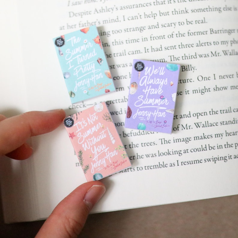 May include: Three small book-shaped stickers with pastel backgrounds and seashell illustrations. The stickers feature titles like "The Summer I Turned Pretty" and "We'll Always Have Summer" by Jenny Han.