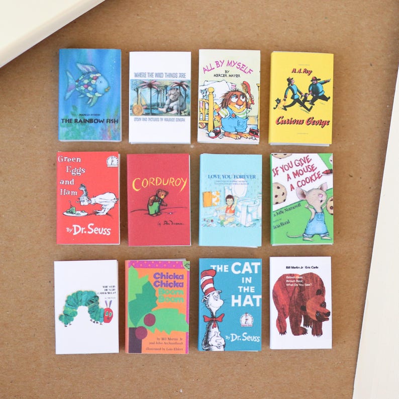 May include: A collection of miniature children's books with colorful covers. Titles include "The Rainbow Fish," "Curious George," and "The Cat in the Hat." The books are arranged on a neutral surface.