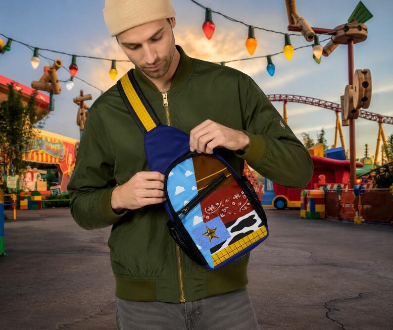 Puede incluir: Un bolso bandolera con un dise&ntilde;o de patchwork que incluye un cielo azul con nubes blancas, una secci&oacute;n marr&oacute;n, un patr&oacute;n de bandana roja, un estampado de vaca en blanco y negro, una estrella dorada sobre un cuadrado azul y una cuadr&iacute;cula amarilla y naranja.