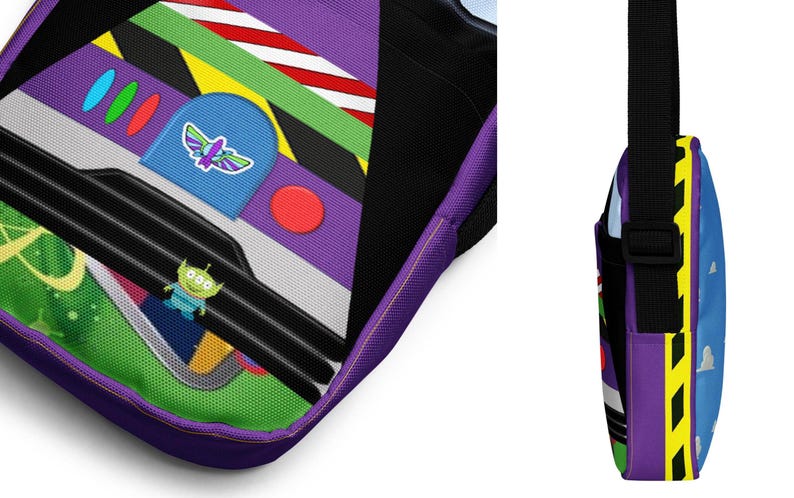 Puede incluir: Bolso bandolera morado y azul con un dise&ntilde;o de nave espacial de dibujos animados. La nave espacial tiene un personaje alien&iacute;gena verde, un bot&oacute;n rojo y una franja amarilla y negra. El bolso tiene una correa ajustable negra.