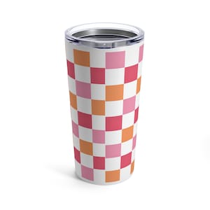 K&ouml;nnte beinhalten: Ein wei&szlig;er Edelstahlbecher mit einem karierten Muster in den Farben Rosa, Orange und Rot.
