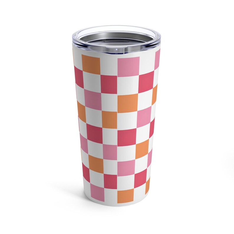 K&ouml;nnte beinhalten: Ein wei&szlig;er Edelstahlbecher mit einem karierten Muster in den Farben Rosa, Orange und Rot.