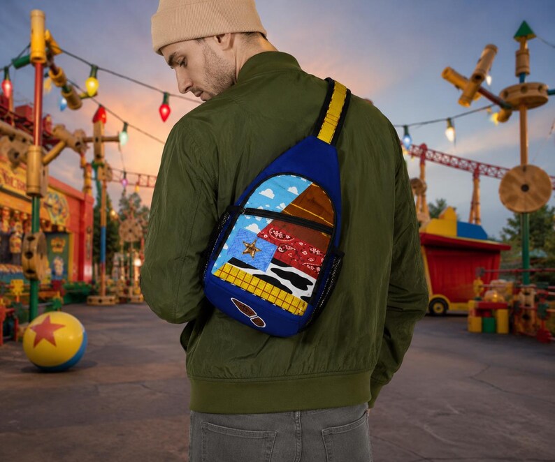 Puede incluir: Una mochila bandolera azul con un dise&ntilde;o de patchwork inspirado en un personaje vaquero, que incluye un patr&oacute;n de cuadros amarillos, estampado de vaca, pa&ntilde;uelo rojo, cielo azul con nubes, una insignia de estrella dorada y una huella de bota.