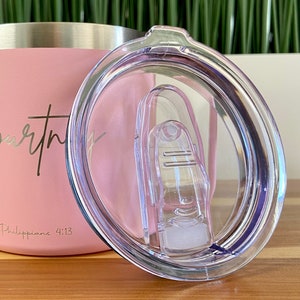 May include: A pink stainless steel tumbler with a clear lid and a white inscription that reads "worthy" and "Philippians 4:13".