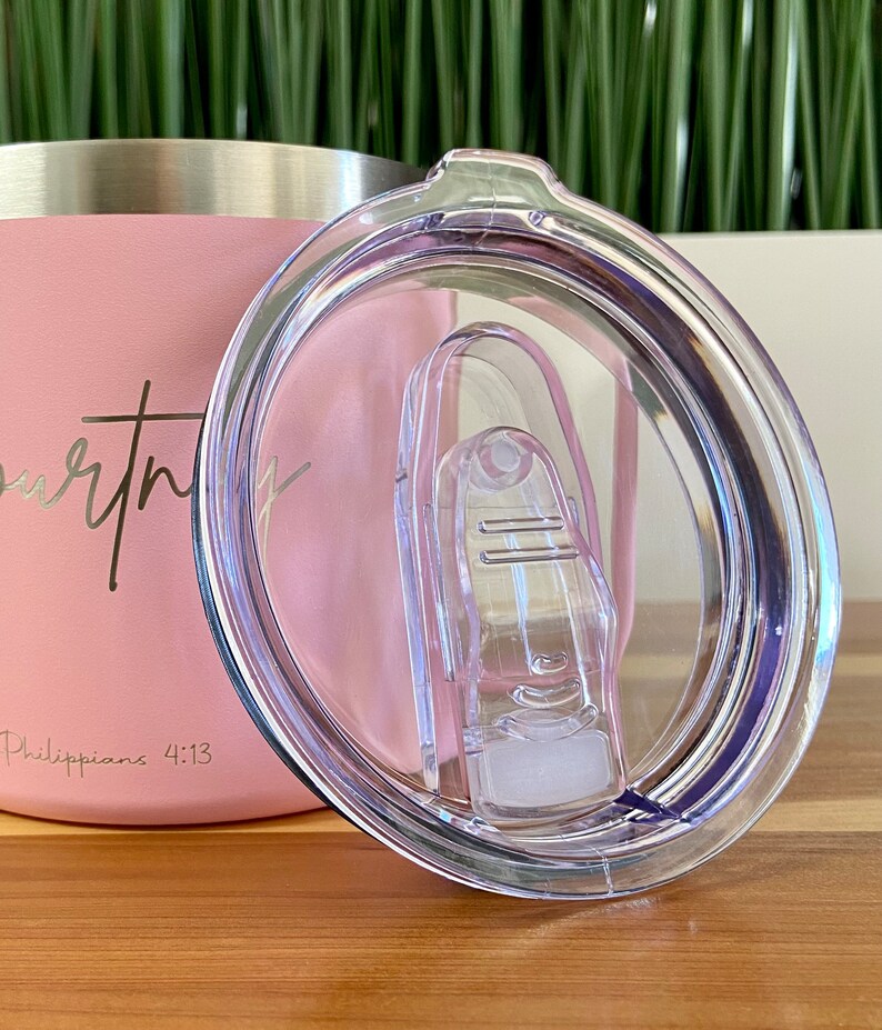 May include: A pink stainless steel tumbler with a clear lid and a white inscription that reads "worthy" and "Philippians 4:13".