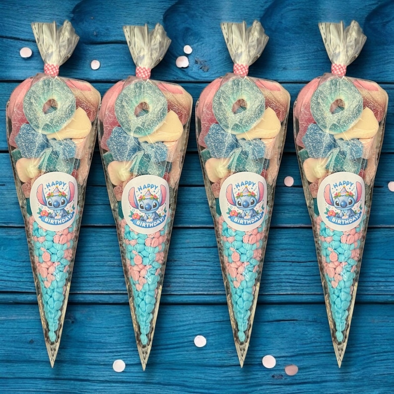May include: Four candy cones filled with a variety of sweets, including blue and pink candies, gummy rings, and other colorful treats. Each cone has a sticker with a cartoon character and the words "Happy Birthday". The cones are tied with a pink ribbon.