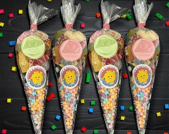 May include: Four clear cellophane cone-shaped bags filled with colorful candies. Each bag is tied with a red and white polka dot ribbon and topped with a clear twist tie. Each bag has a round sticker with a Lego-themed design and the text "Thank You For".