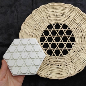 May include: A white hexagonal mould with a geometric pattern, sitting on top of a woven wicker placemat.