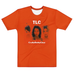 May include: Orange t-shirt with a graphic of the musical group TLC. The design features portraits of the three members, with the band's name and the album title "CrazySexyCool" printed in white.