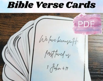 Może przedstawiać: Stos kart z wersetami biblijnymi o zaokrąglonych rogach. Karty mają akwarelowe tło z tekstem "We love because He first loved us. 1 John 4:19." Widoczne są również słowa "Bible Verse Cards" i "Instant Download".