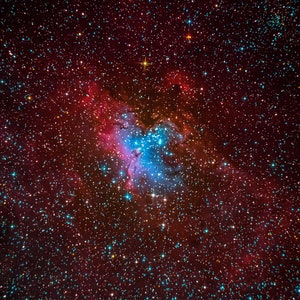 May include: A vibrant nebula with a mix of red, blue, and purple hues, surrounded by a field of twinkling stars.